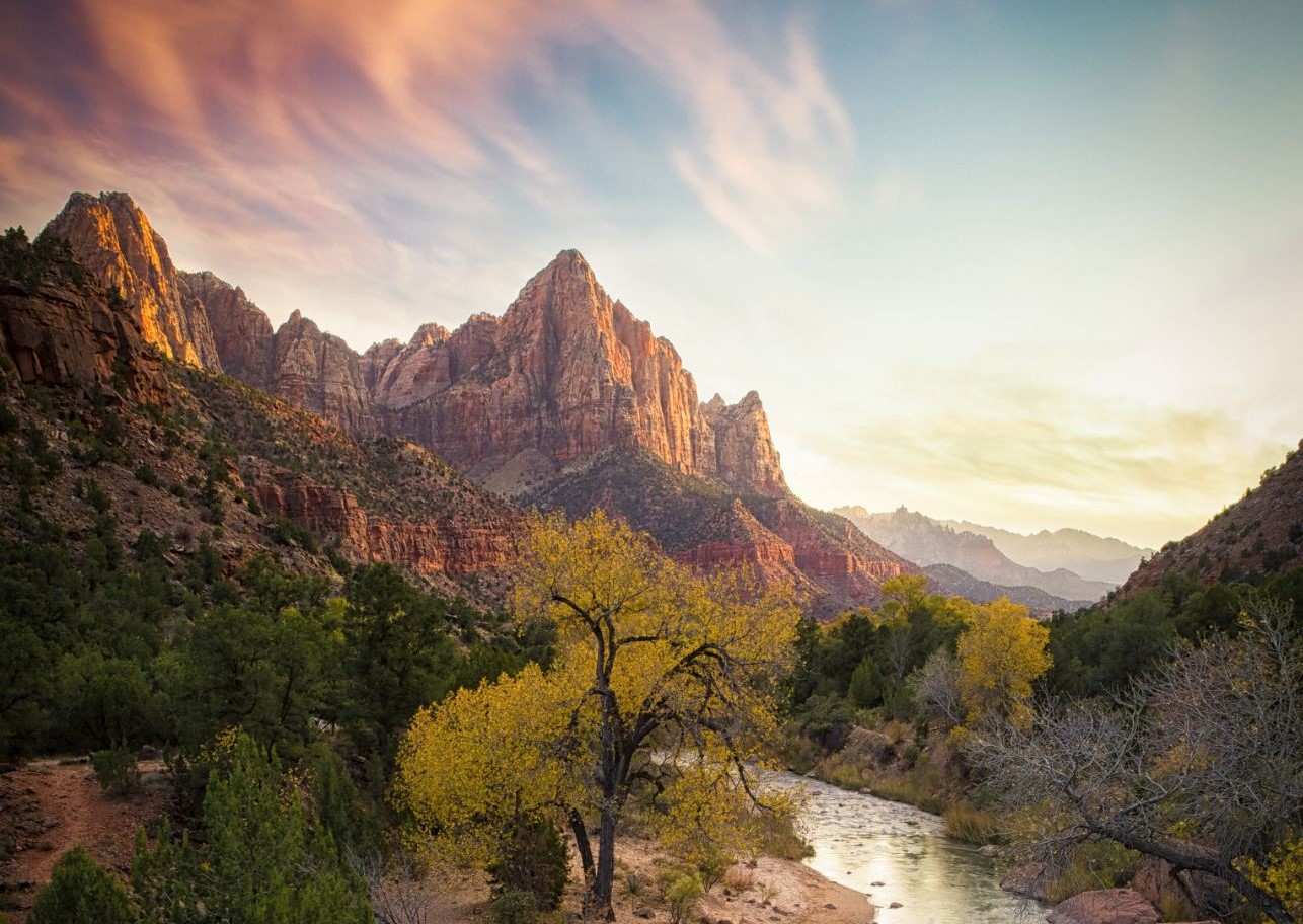 Sunset light over Zion Canyon, with autumn trees beside the Virgin River